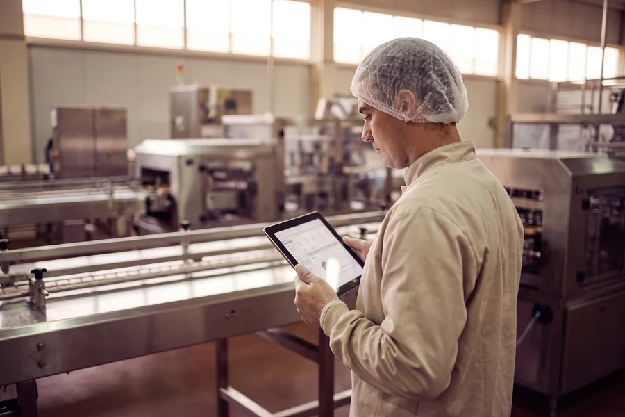 Operator recording production checks on a tablet at the line