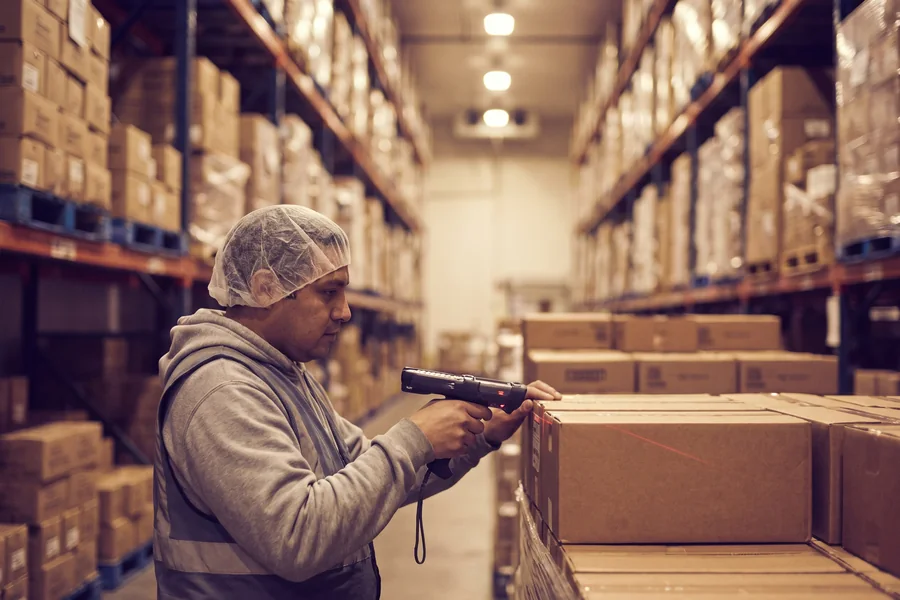 Worker scanning a carton barcode in a food warehouse